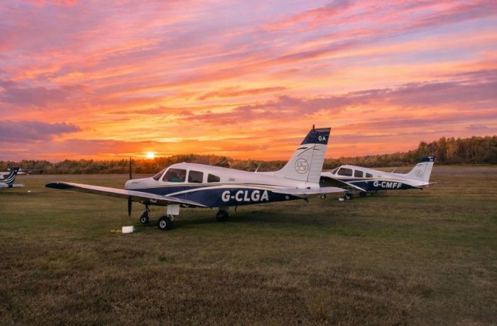 Sunset over two parked planes on airfield