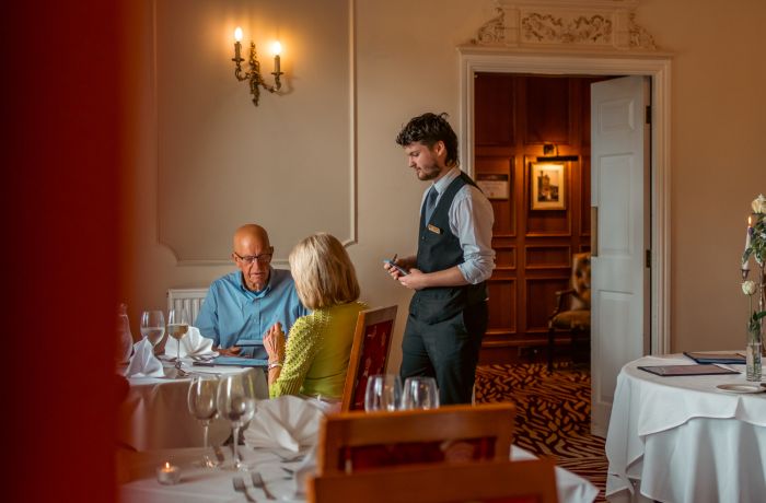 Waiter taking order from couple at bagden hall restaurant