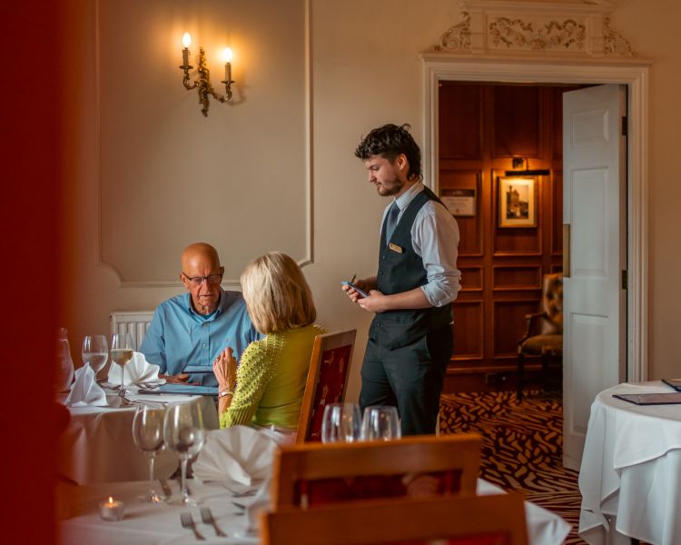 Waiter taking order from couple at bagden hall restaurant