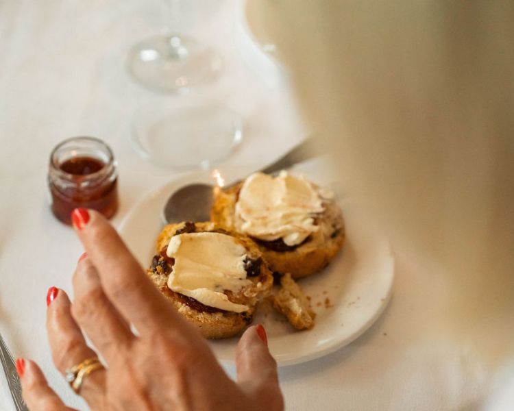 Spreading jam and cream on scone at grinkle park afternoon tea