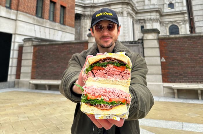 Man holding sandwich on a food mystery tour in london