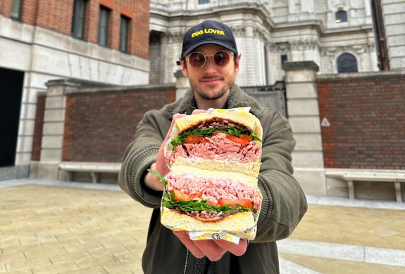 Man holding sandwich on a food mystery tour in london