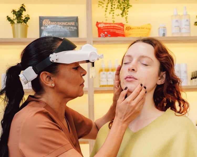 Facialist looking at clients skin