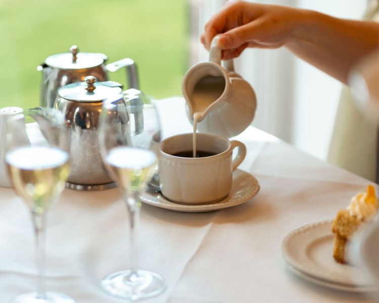 Pouring milk in tea at afternoon tea at farington lodge