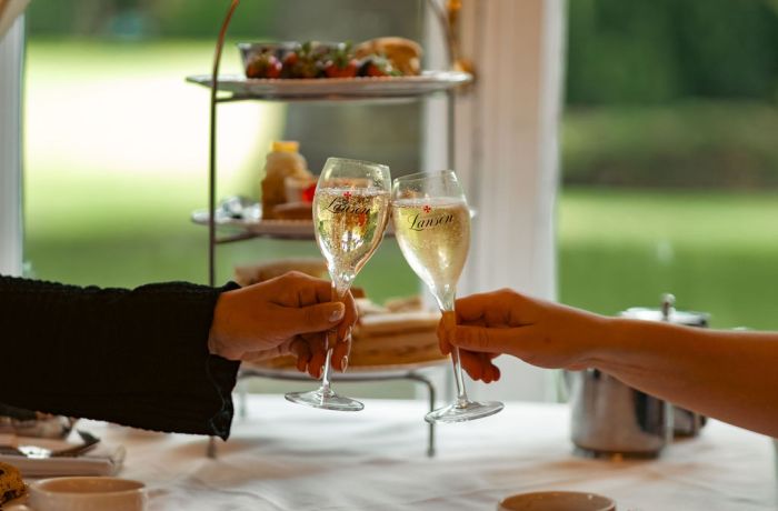 Cheers with champagne in front of afternoon tea at farington lodge