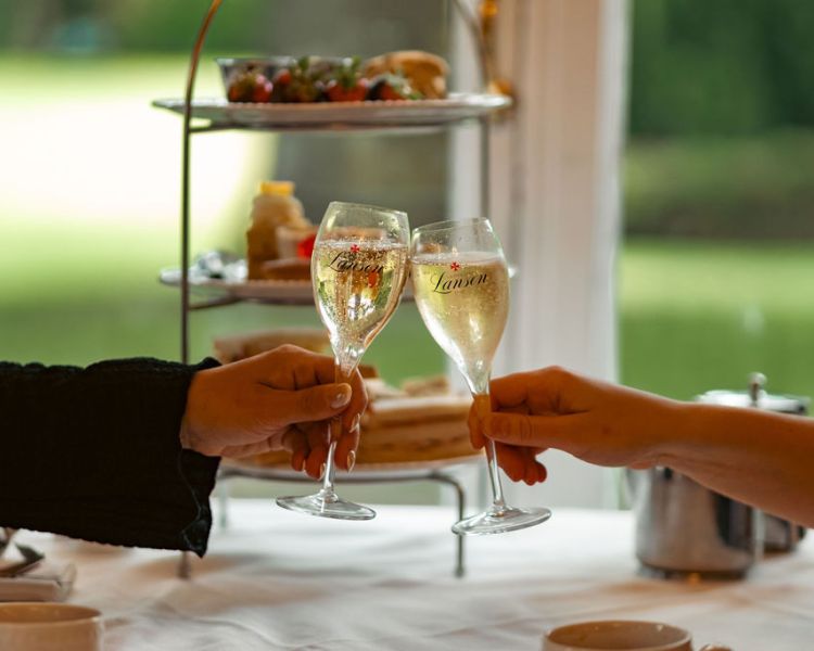 Cheers with champagne in front of afternoon tea at farington lodge
