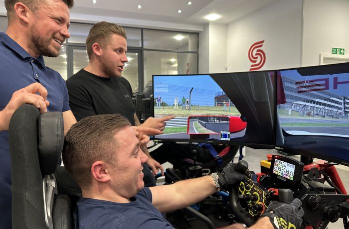 Men stood by a driving sim