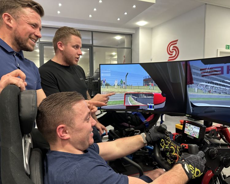 Men stood by a driving sim
