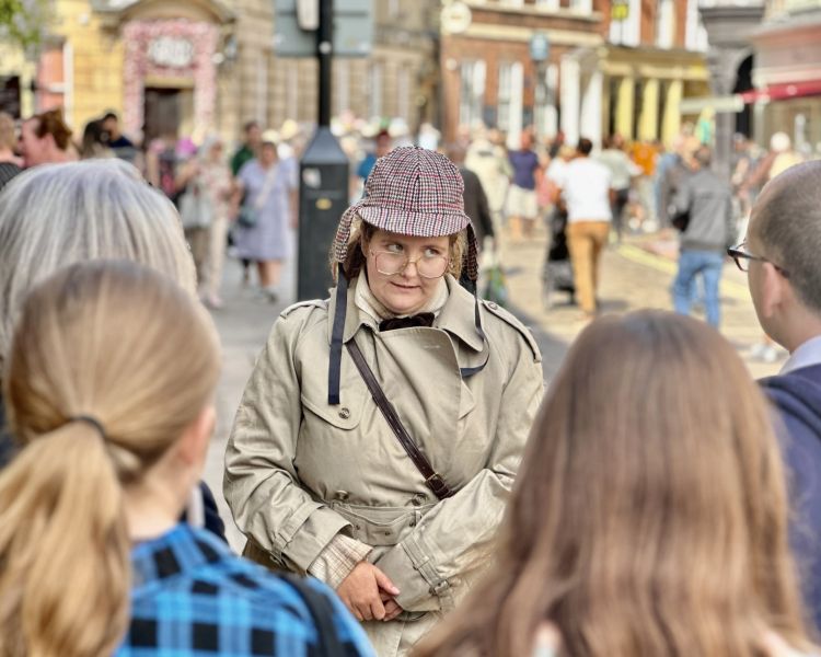 guide talking to group on busy street on a historical walking tour in york