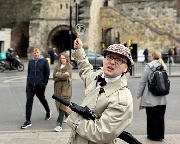 guide pointing to building on a historical walking tour in york