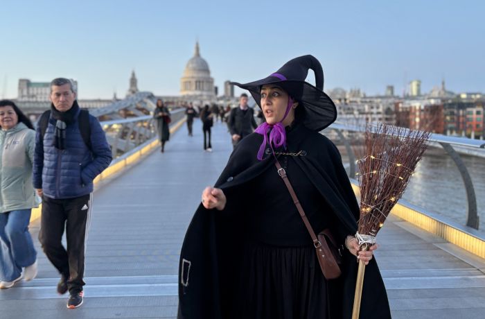 guide dressed as witch on bridge in london on a witches walking tour in london