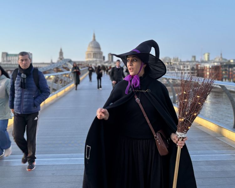 guide dressed as witch on bridge in london on a witches walking tour in london