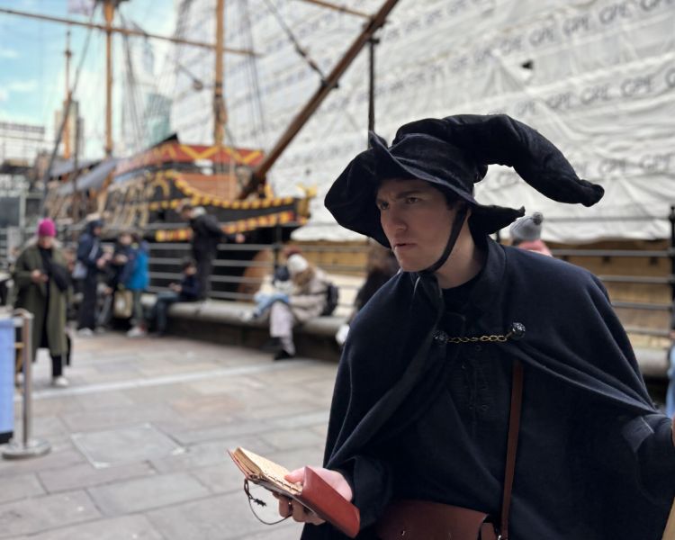 guide talking to group by river on a witches walking tour in london