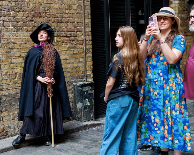 guide and group looking up on a witches walking tour in london