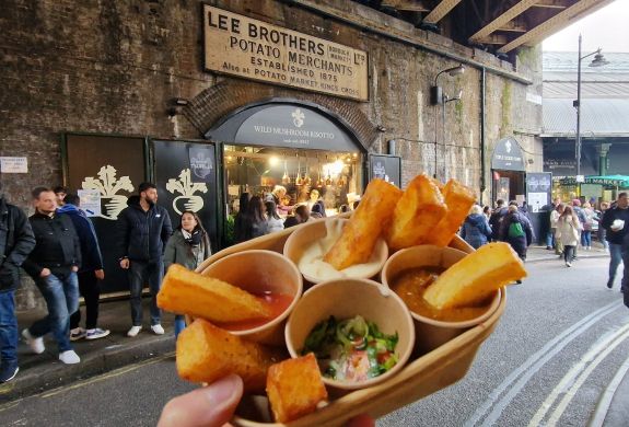 Chips and dips held up in front of chip vendor in borough market
