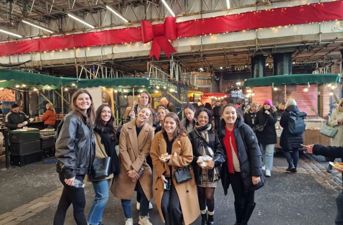 Tour group posing for photo inside londons borough market on a food tour