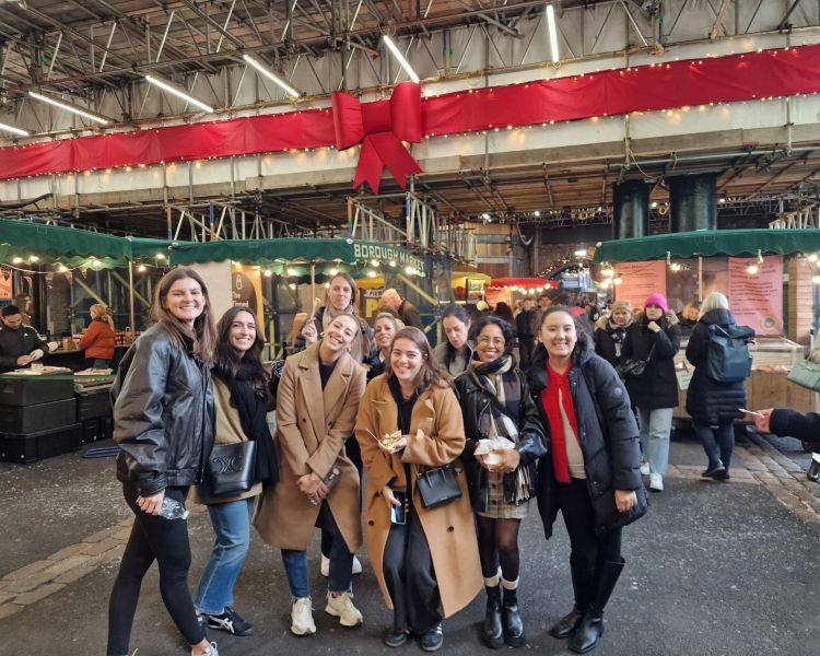 Tour group posing for photo inside londons borough market on a food tour