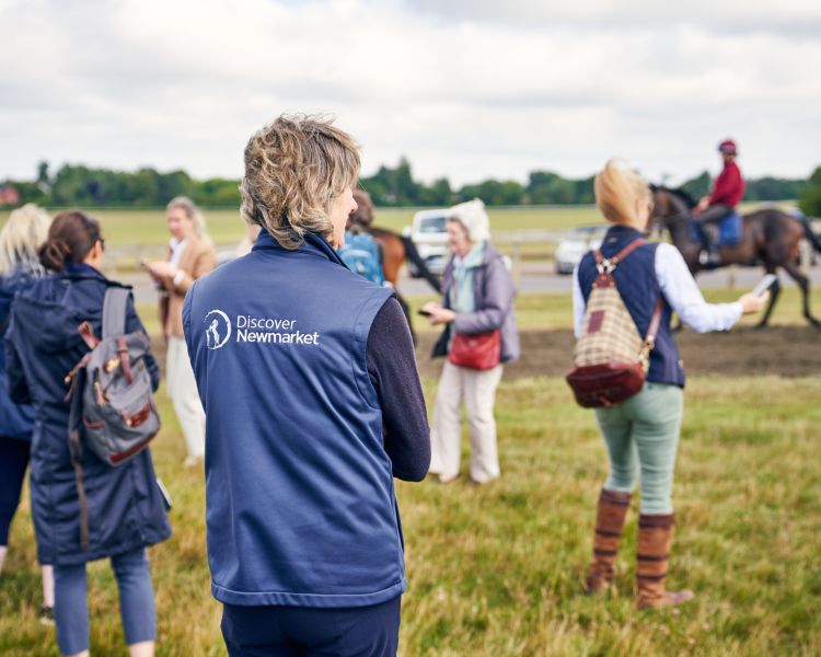 Tour group watching horses at gallops at newmarket