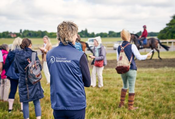 Tour group watching horses at gallops at newmarket