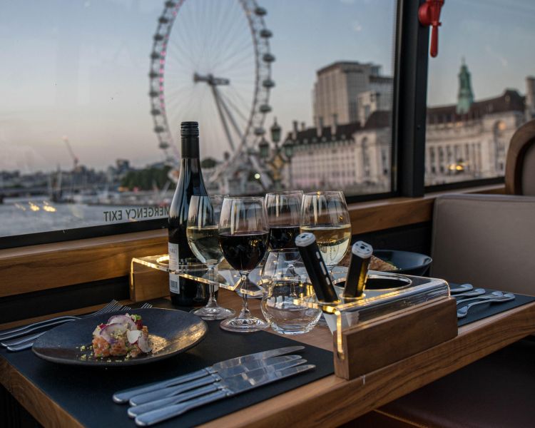 View of london eye from table set for dinner on bustronome london dining bus