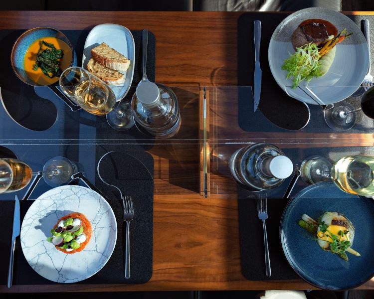 Table set with food and wine on bustronome london dining bus