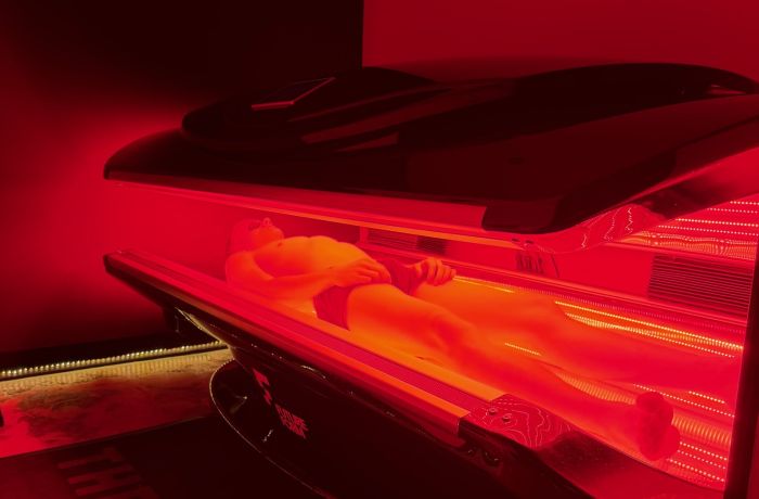 Person lying in red light therapy bed for treatment at thriyv in manchester