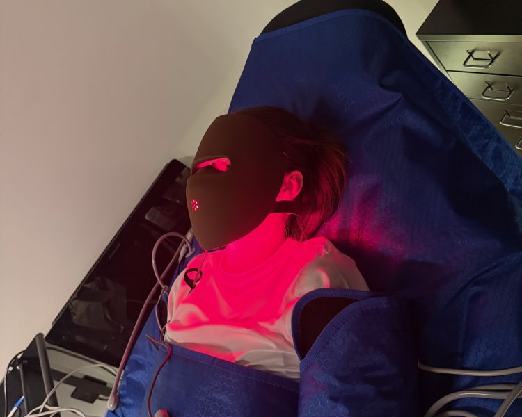 Woman having lymphatic drainage treatment whilst wearing led face mask