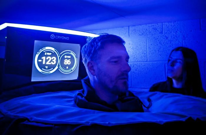 Man inside cryotherapy chamber with head exposed and temperature on screen