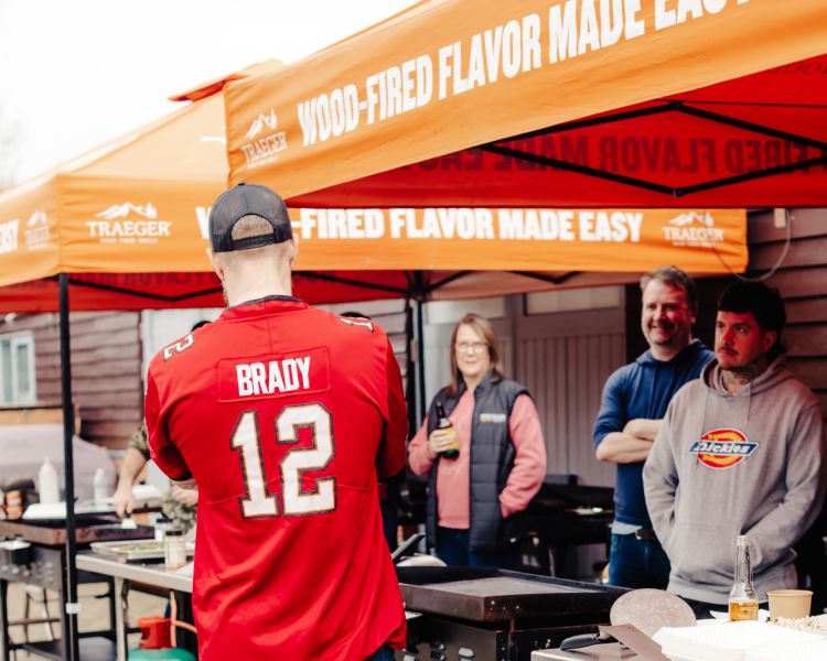 people listening to instructor on a blackstone griddle bbq class