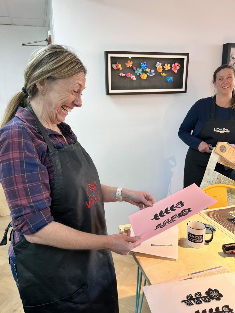 lady pleased with her printed design made on a lino printing workshop