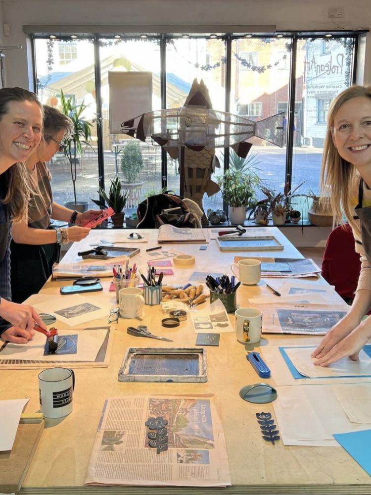 people around a table on a lino printing workshop