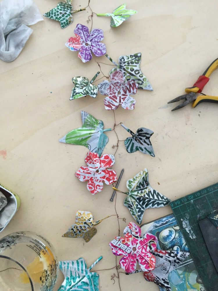 a flower and leaf garland made from recycled metal drinks cans