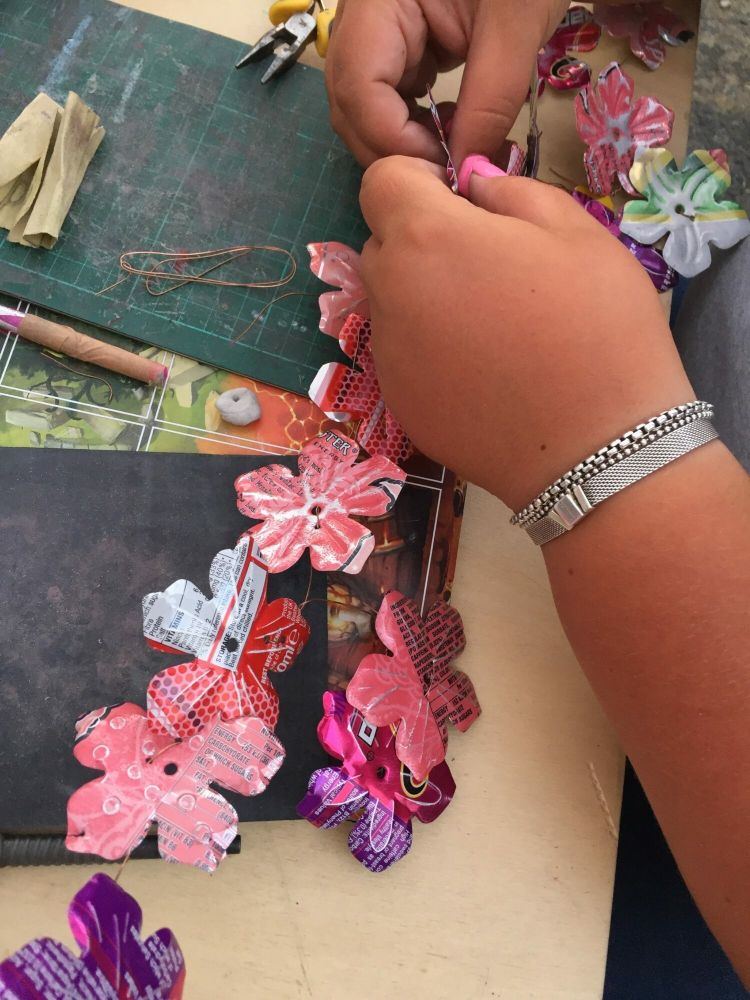 making a flower garland made from recycled metal drinks cans