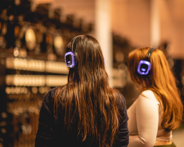 two girls wearing audio headsets on tour of control room b at battersea power station