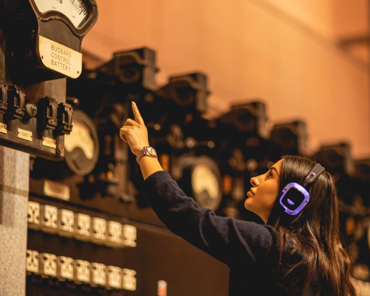 woman wearing headset on audio tour of control room b at battersea power station