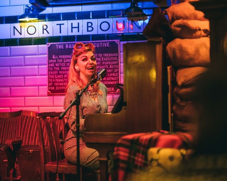 singer dressed in 1940s dress at cahoots underground 1940s style bar in london