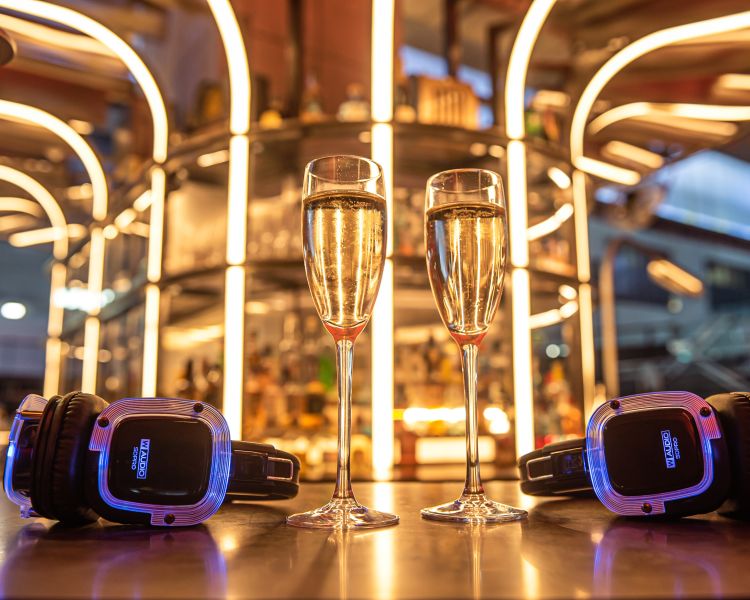 Two glasses of champagne and two headsets at control room b tour