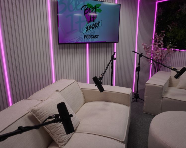 white podcast studio with comfy chairs and microphones