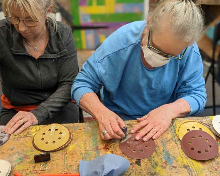 ladies sanding resin art pieces made on one day course in somerset