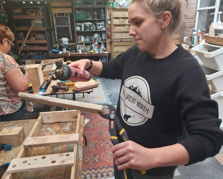 woman working with wooden pallets on a pallet upcycling course