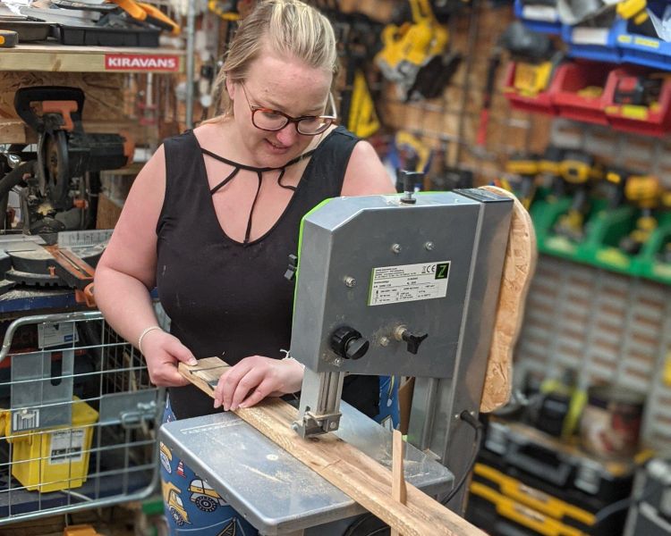 woman cutting wood from pallets on a pallet upcycling day course