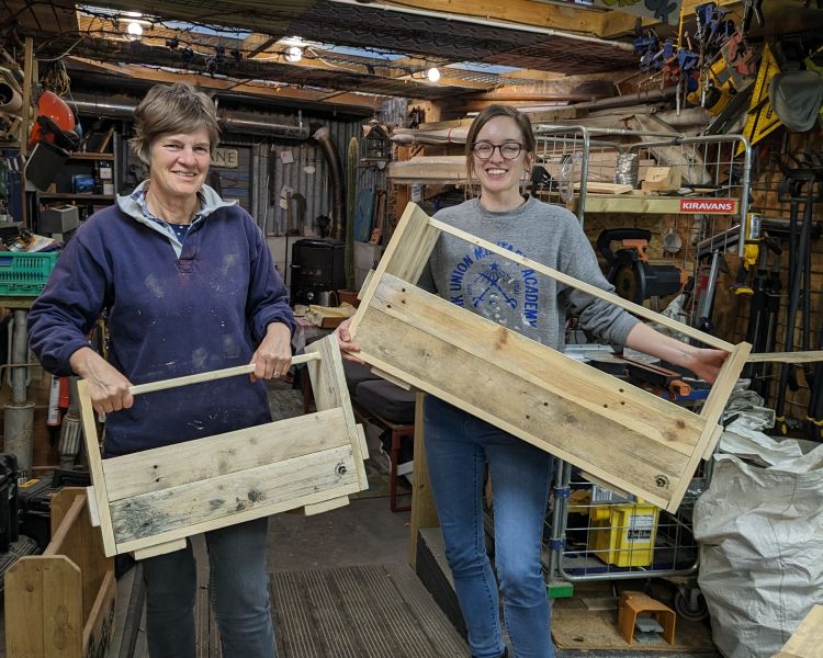ladies with their pieces made on a pallet upcycle course