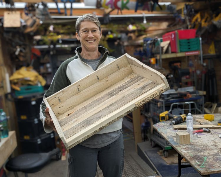 woman holding what he's made from wooden pallets on a day course in somerset