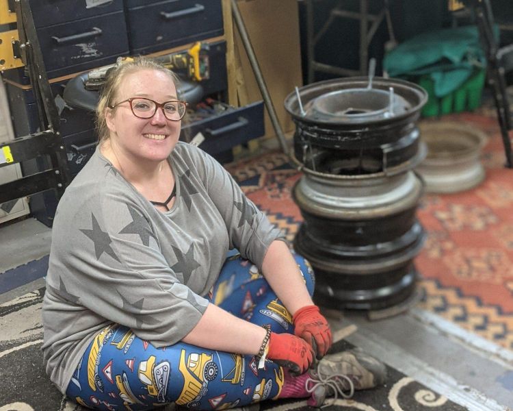 woman sitting next to a fire pit she made on a one day course