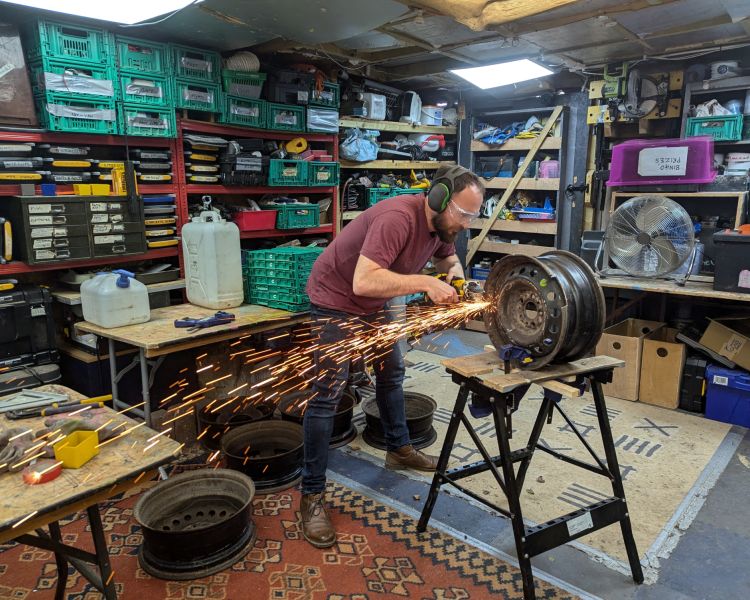 man cutting metal for fire pits