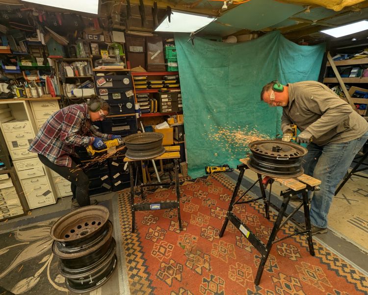 people in workshop cutting metal for fire pits