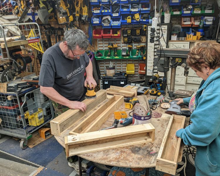 man and woman in workshop making bug house on one day course