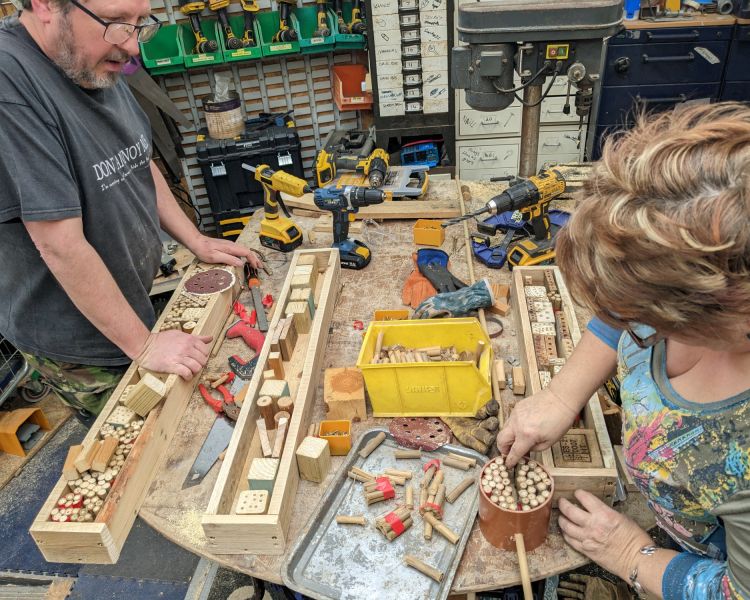 man and woman making bird houses from wood offcuts on one day course in somerset