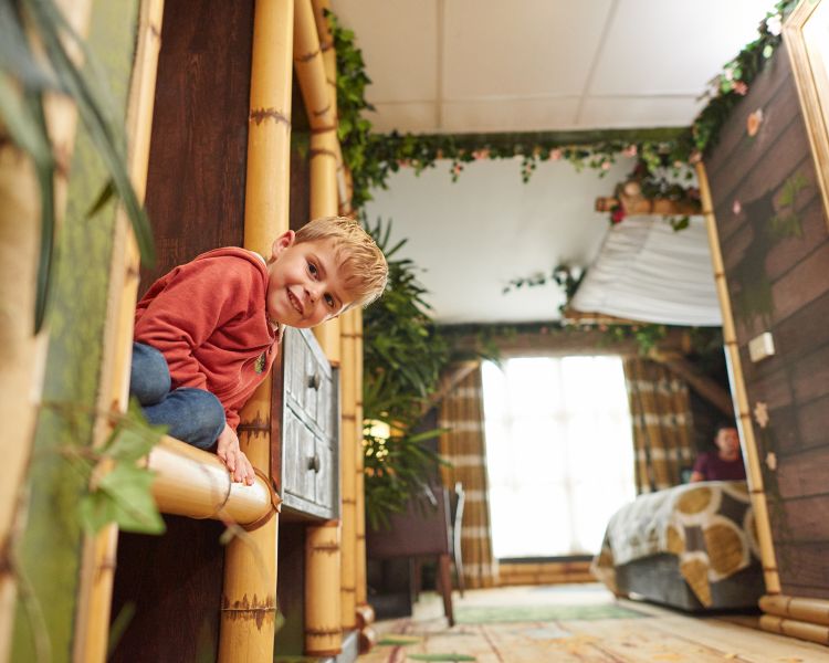 boy in the penguins of madagascar themed room in the safari hotel at chessington world of adventures