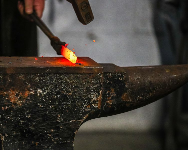 shaping hot metal with hammer on blacksmith experience in peak district